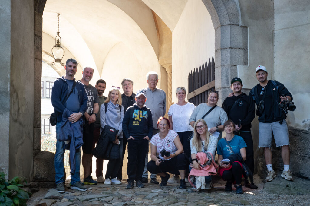 Skupina účastníků Location Tour 2026 pod klenutou branou zámku Jindřichův Hradec